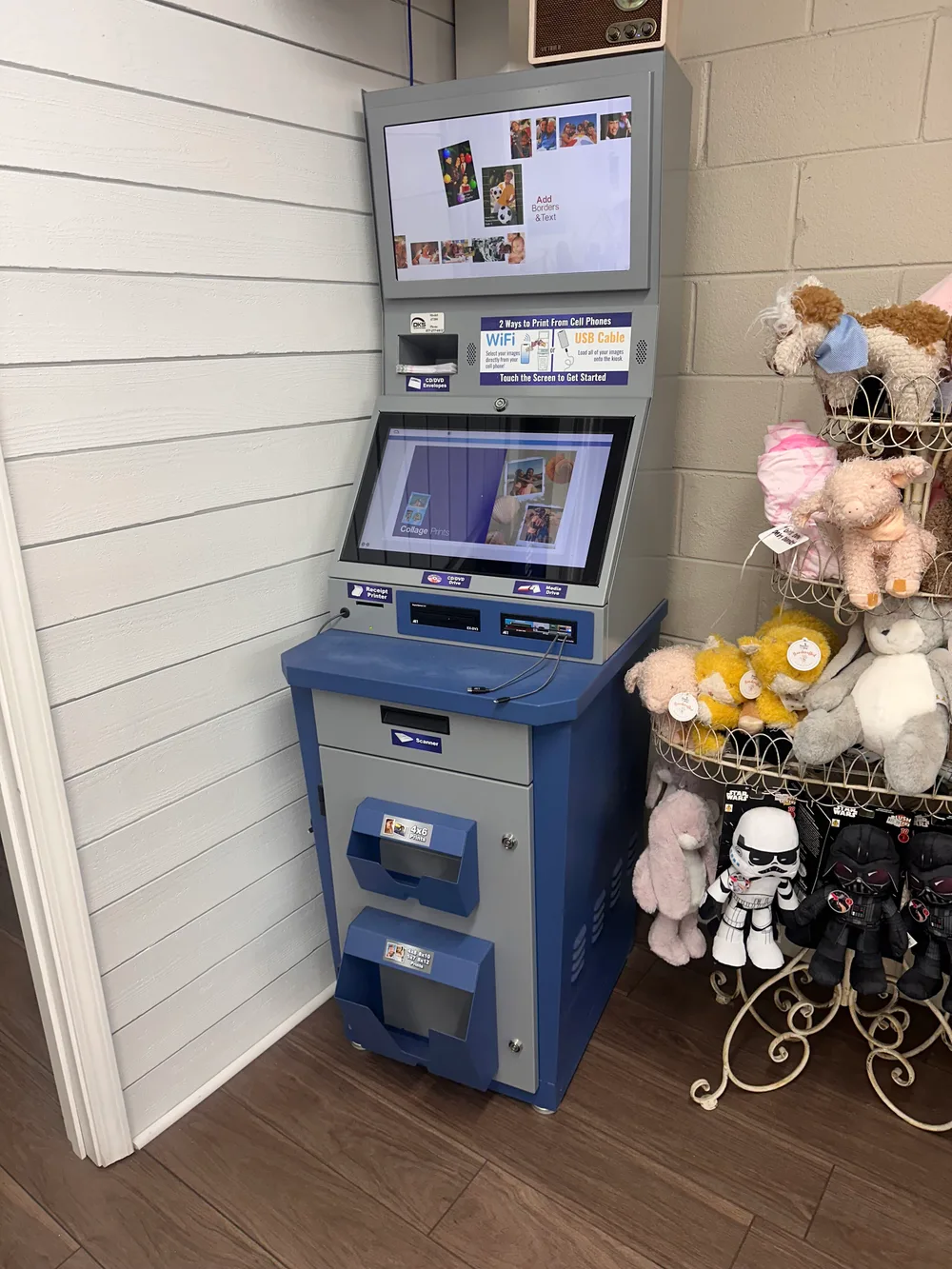 The photo printing kiosk inside City Drugs, with two screens for ordering prints from your phone by WiFi or USB cable